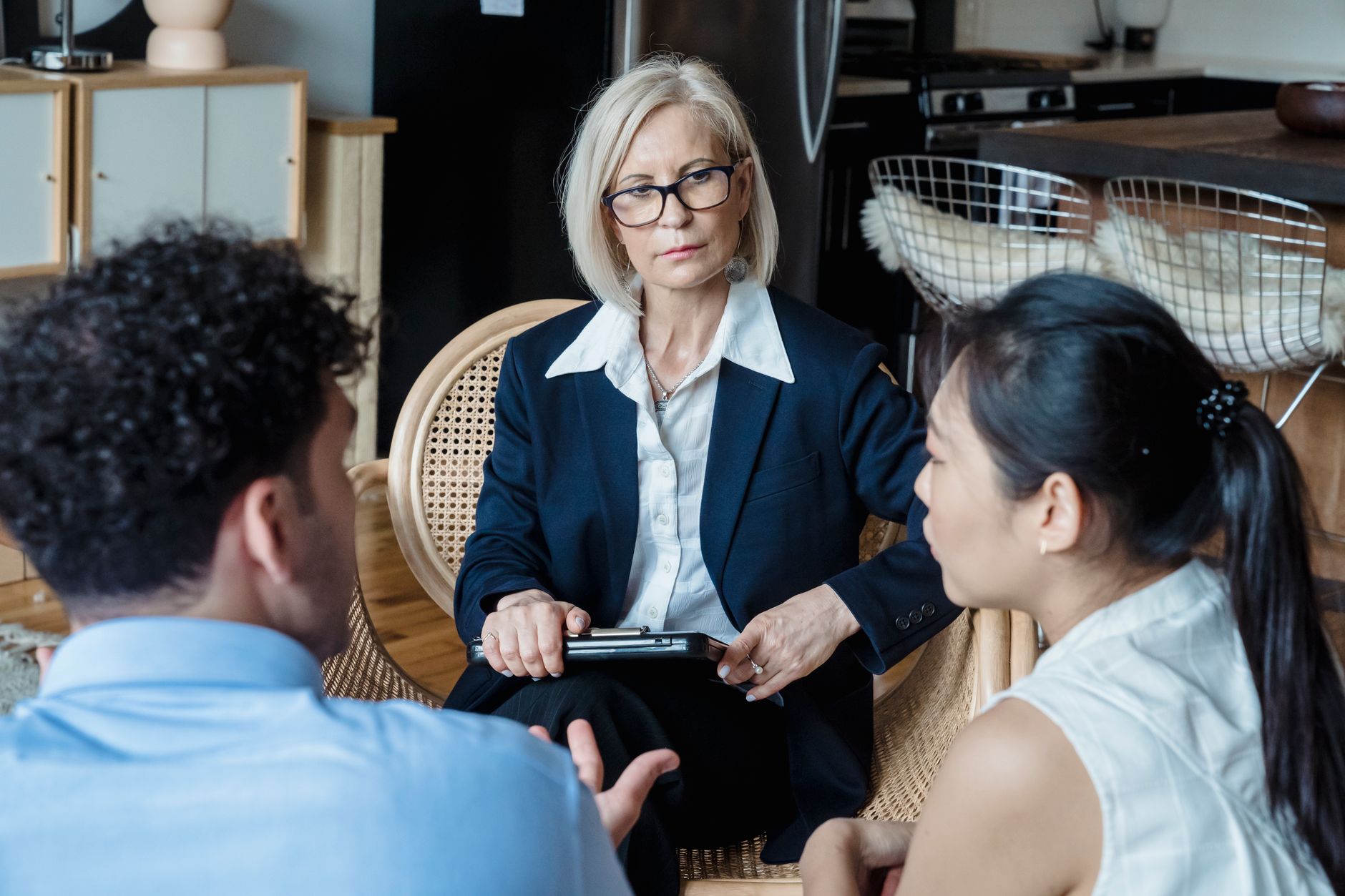 Senior couple talking with caring legal counselor in warm library